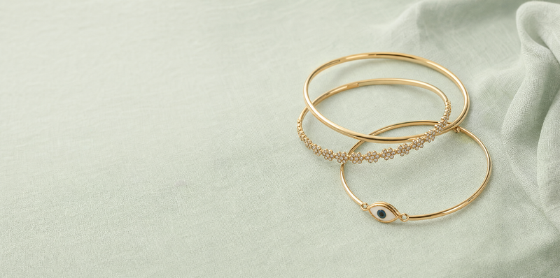 Bracelets from Rs 30 - three slim gold-tone bangles on sage linen